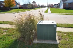 Green pad-mount transformer in neighborhood yard