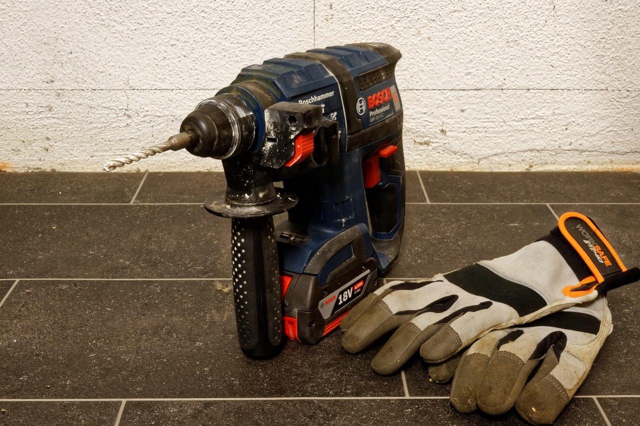 A power drill and a pair of work gloves.