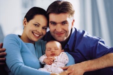 A young couple holding a baby